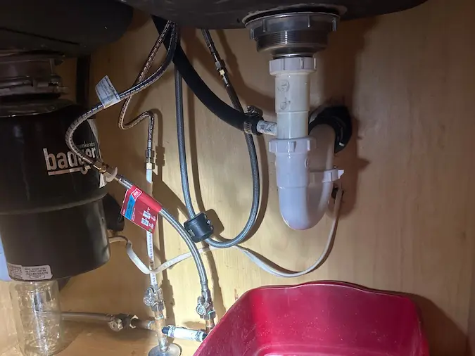 Under sink P-trap and bucket during clogged drain inspection