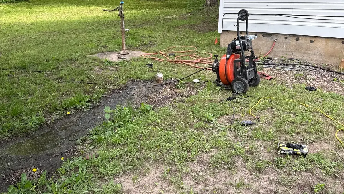 Main sewer cleaning equipment positioned at a residential exterior cleanout