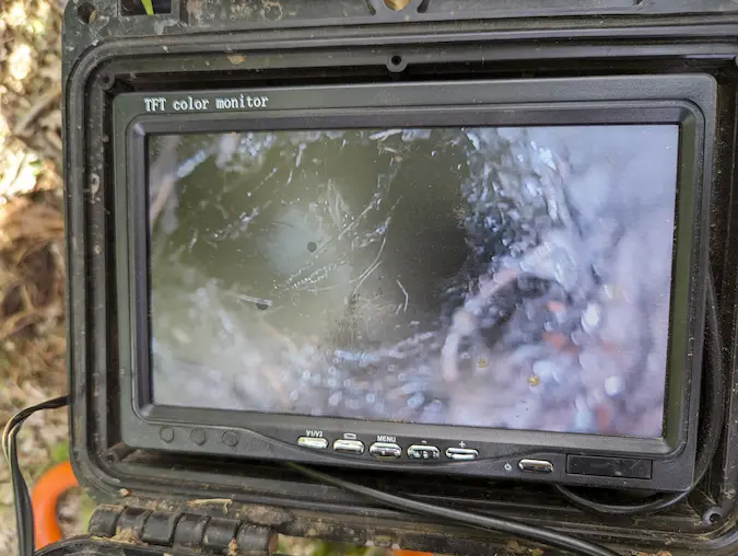 Sewer camera monitor displaying a live view from inside an underground sewer line