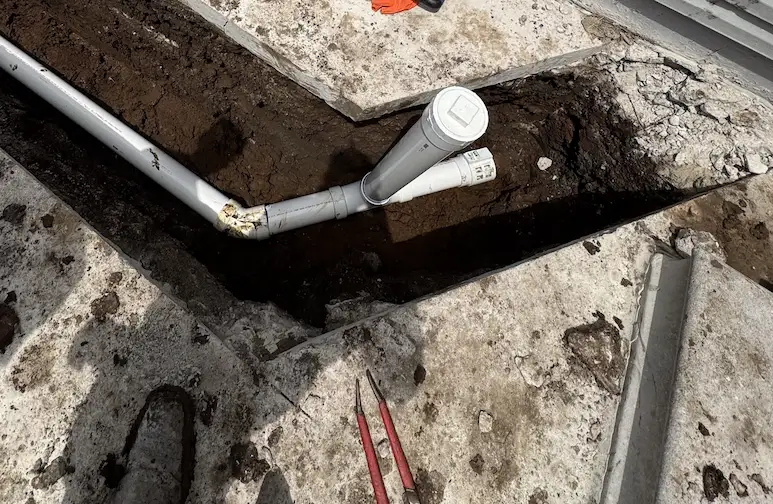 New PVC sewer line and two-way cleanout installed beside a building in El Dorado Kansas