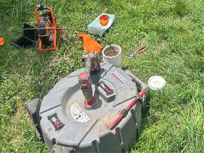 Sewer camera equipment arranged beside an exterior cleanout
