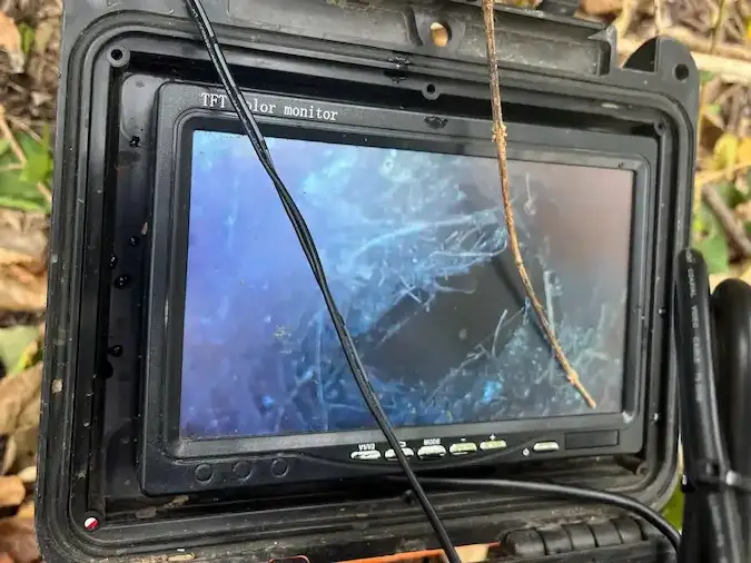 Sewer camera monitor showing material inside the visible pipe