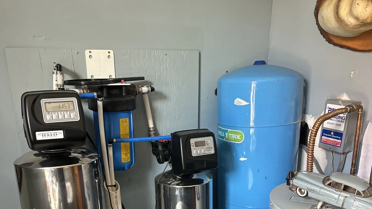 Installed HALO water-treatment tanks and a blue filter housing with nearby plumbing equipment