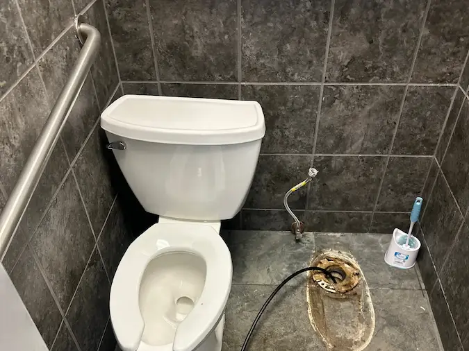 Toilet removed for clogged toilet and drain cleanout access