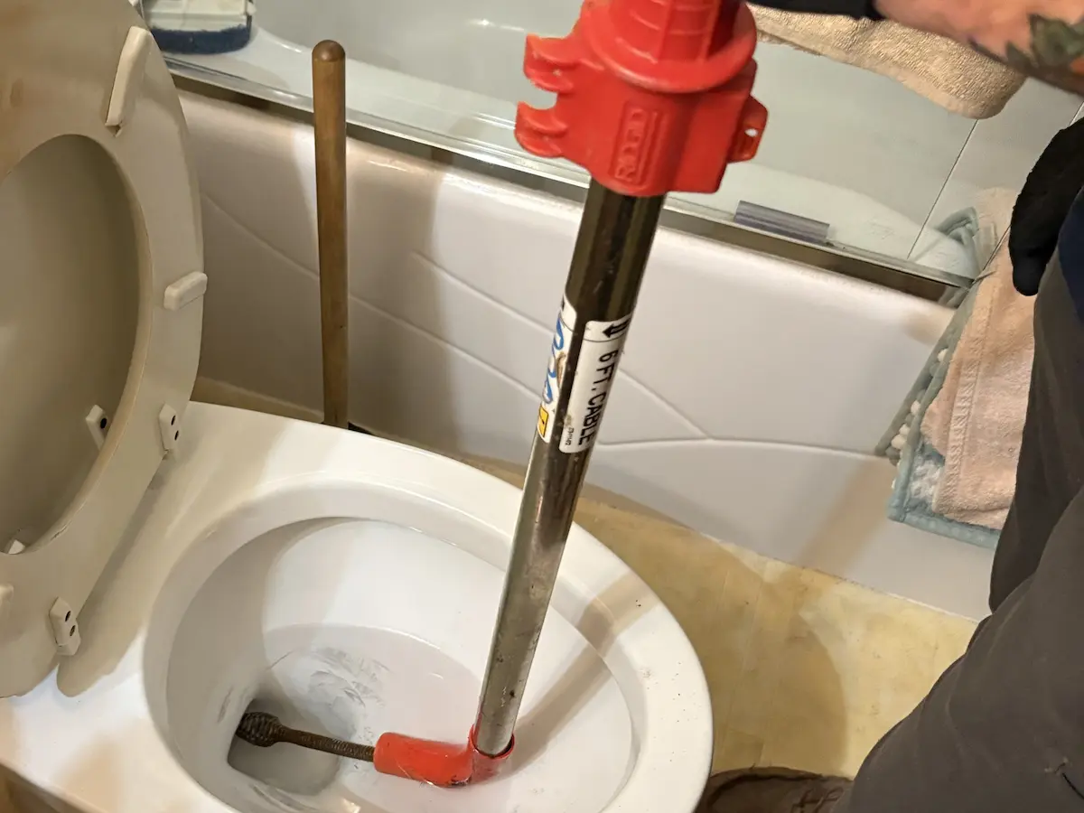 Professional toilet clog removal with drain-cleaning equipment