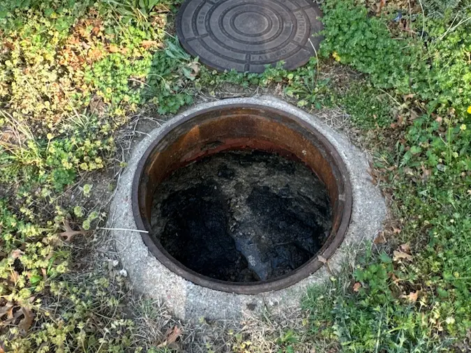 Commercial sewer manhole access used for main-line cleaning equipment