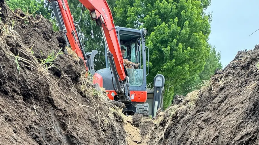 PD Plumbing sewer line repair excavation with mini excavator in a Wichita-area yard