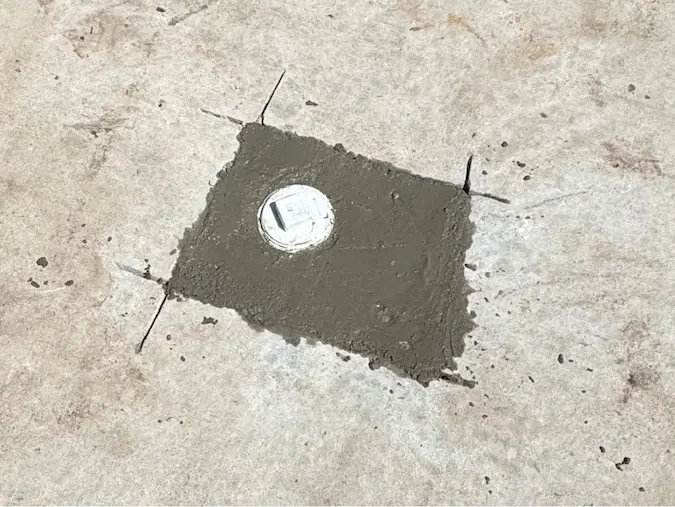 Exterior sewer cleanout completed with a concrete patch