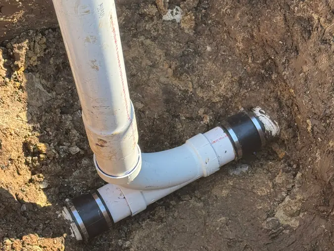 New PVC cleanout and sewer connection installed during a localized repair
