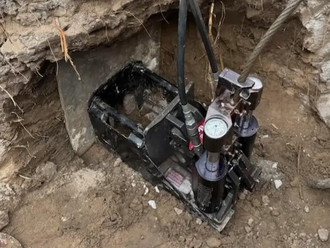 Pipe bursting machine positioned in a controlled access point