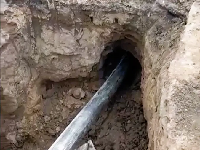 Pipe bursting sewer replacement near a residential driveway