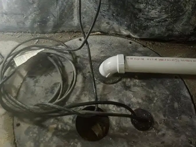 Sump pump basin and discharge piping setup in a basement