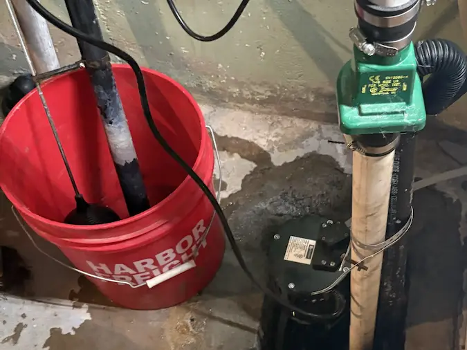 Sump pump repair diagnosis with pump and piping near a wet basement floor