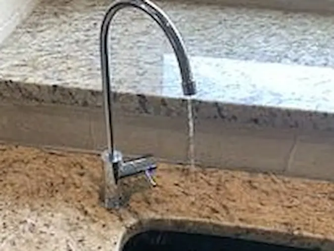 Dedicated filtered drinking-water faucet beside a kitchen sink