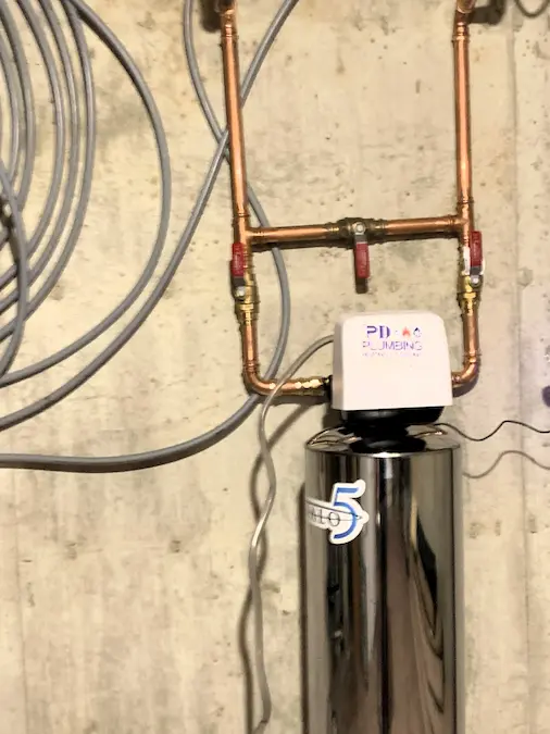 HALO 5 whole-home filtration tank connected to copper piping and bypass valves