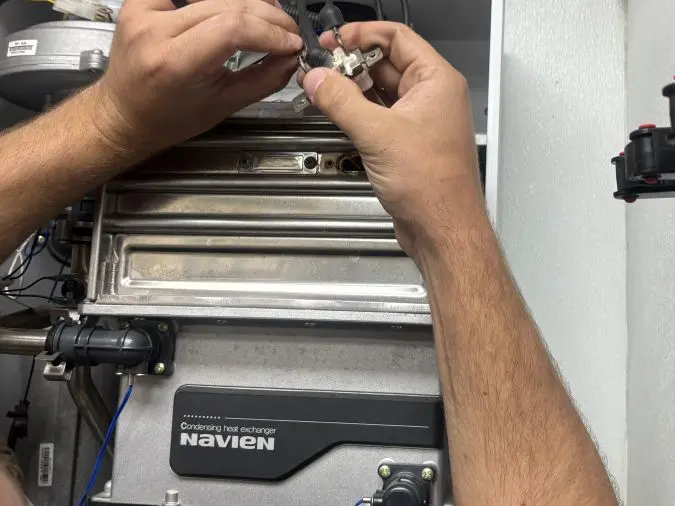 PD Plumbing technician servicing an opened tankless water heater