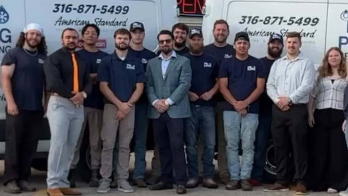 PD Plumbing Heating and Cooling team standing between branded service vans
